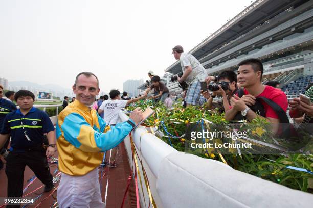 Jockey Gerald Mosse gives his autograph to racing fans at Sha Tin racecourse during Season Finale race day on July 12 , 2015 in Hong Kong.
