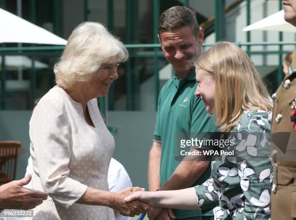 Camilla, Duchess of Cornwall, is greeted by head groundsman, Grant Cantin, and the Wimbledon Museum curator, Anna Renton as she attends day nine of...