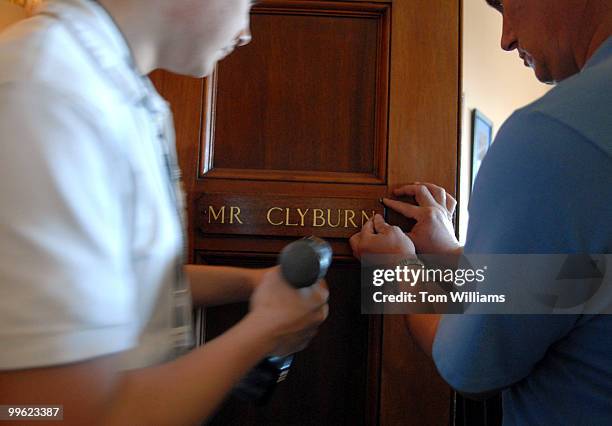 William Slack, left, and Gary Bullis of the Architect of the Capitol's woodcrafting division, install the name plate of Rep. James Clyburn, D-S.C.,...