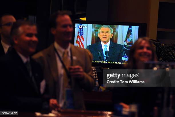 Convention goers in a private party watch President George W. Bush address the crowd via satellite on second night of the Republican National...