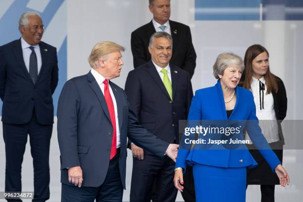 President Donald Trump reaches out to British Prime Minister Theresa May at the 2018 NATO Summit at NATO headquarters on July 11, 2018 in Brussels,...