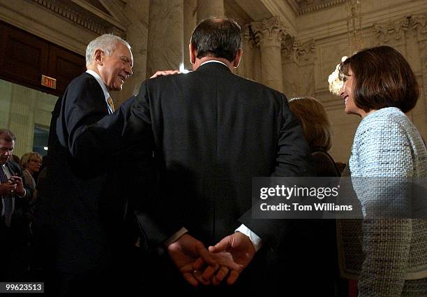 Judge John G. Roberts Jr., back to camera, gets a pat on the back from Sen. Orrin Hatch, R-Utah, after the first day of the Senate Judiciary...