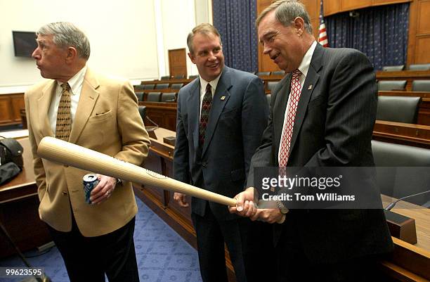 Rep. Mike Oxley, R-Ohio, checks outs a bat given to him by Bill Sells, center, of Sporting Goods Manufacturers Association after check presentation...