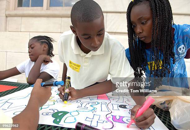 Donte Paige and Brianna Tillman, 5th graders from Crosby S. Noyes Elementary in Northeast, make signs for a news conference to announce the release...