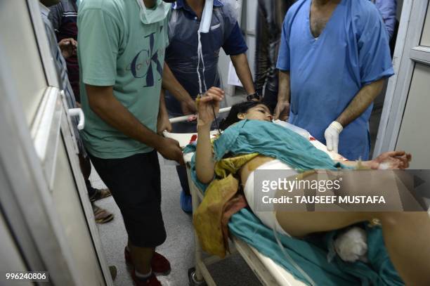 Injured Kashmiri girl Razia Khursheed lays on a stretcher at a hospital in Srinagar on July 11 where they were brought after being wounded in a blast...
