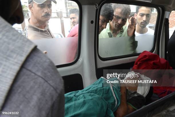 An injured Kashmiri boy cries inside an ambulance at a hospital in Srinagar on July 11 where they were brought after being wounded in a blast after a...