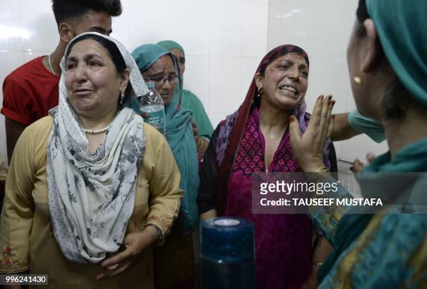 Relatives of injured children cry at a hospital in Srinagar on July 11 where they were brought after being wounded in a blast after a group of...