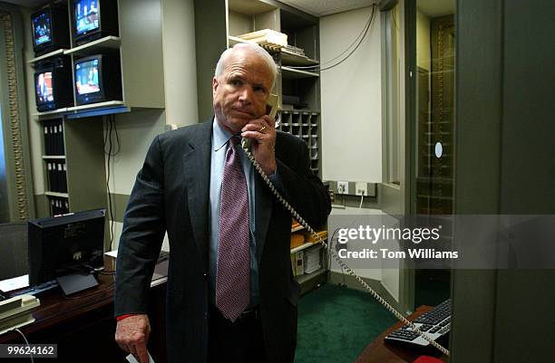 Sen. John McCain, R-Ariz., makes a phone call to let Senators not yet at the news conference, that they are ready to speak to the press the...