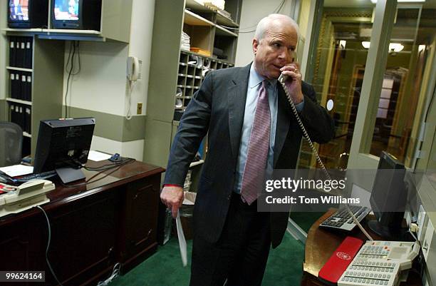 Sen. John McCain, R-Ariz., makes a phone call to let Senators not yet at the news conference, that they are ready to speak to the press the...