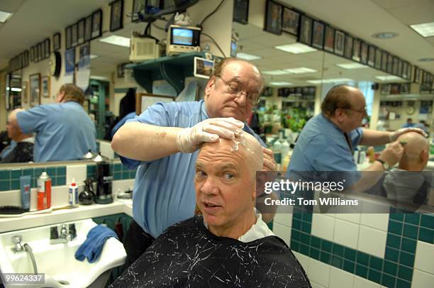 Carl Parks, an executive with National Association of Mutual Insurance Companies , gets his head shaved by Mario D'Angelo in the Senate barber shop...