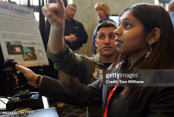 Major Andy Davidson Taylor of the U.S. Air National Guard instructs Presidential Classroom student Puja Patel of Texas, on a F-16 flight simulator,...