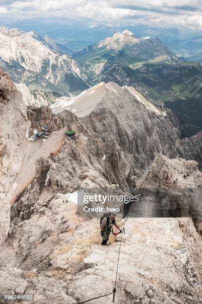 female moutaineers on the marino bianchi via ferrata, below the lorenzihuette refuge and the mountain station of the cable car, 2932 m, at the back mt duerrenstein, 2839 m, cristallo group ampezzo dolomites, cortina d'ampezzo, province of belluno - dampezzo stock pictures, royalty-free photos & images