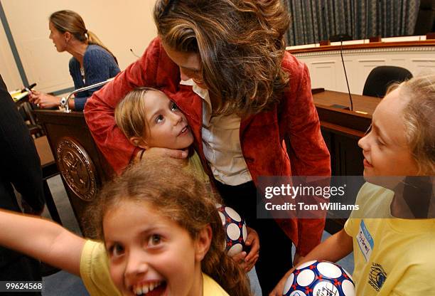 Olympic Gold Medal for the US soccer team, Julie Foudy, fools around with Caroline Fitzgerald of the Kiwanis Arlington Soccer Team, during a...