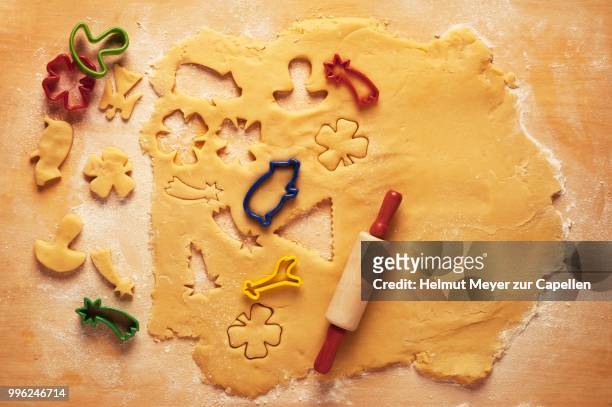 cake dough with a rolling pin and cookie cutters - rolling pin stock-fotos und bilder