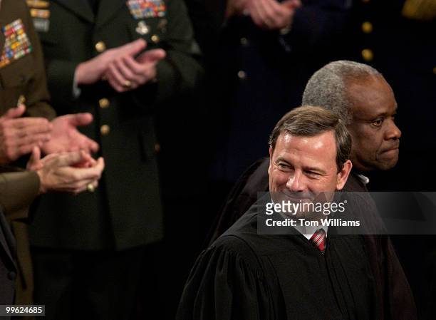 Chief Justice of the Supreme Court John Roberts, foreground, and associate justice Clarence Thomas, wait for more justices to enter the House...