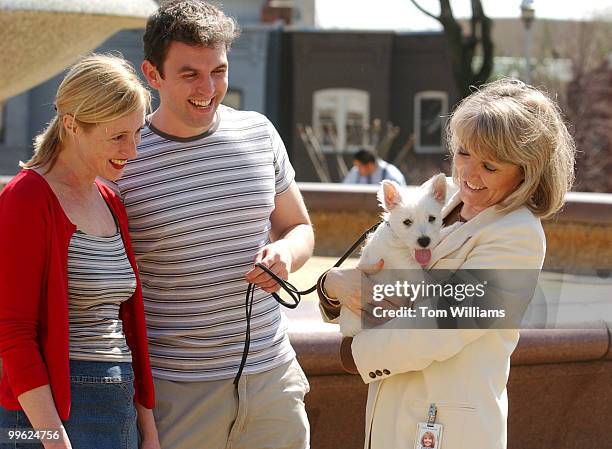 Capitol Hill residents Cathy McSweeny and Paul Dowling let Mary McHugh of the Committee on House Administration, hold their dog "Felix Noble", a West...