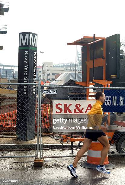 Man runs past construction near the Navy Yard Metro near the Nationals new baseball stadium.