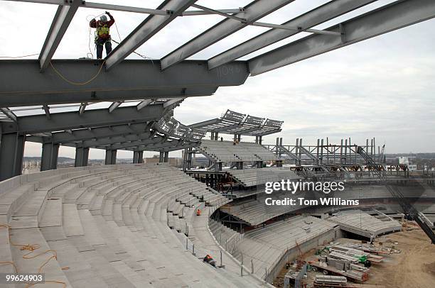 Worker walks on a beam for the overhang that will cover upper deck seats on the construction site of the Nationals new baseball stadium scheduled to...