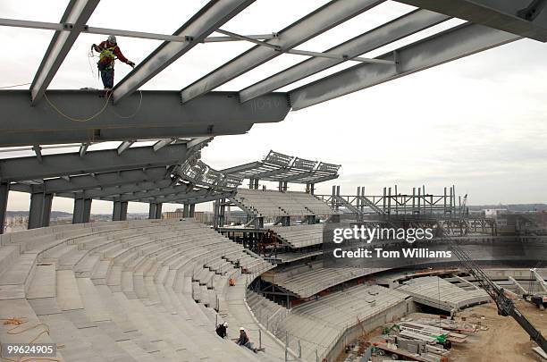 Worker walks on a beam for the overhang that will cover upper deck seats on the construction site of the Nationals new baseball stadium scheduled to...