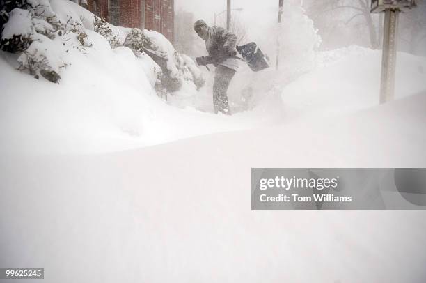 Albert Mills shovels a sidewalk on C Street, NE, during a winter storm expected to bring 10-15 inches of snow in the District with gust of winds near...