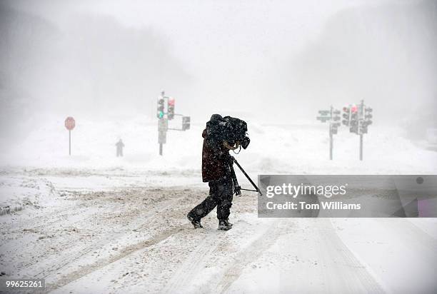 Cameraman from FOX News crosses North Capitol Street while shooting video of a winter storm expected to bring 10-15 inches of snow in the District...