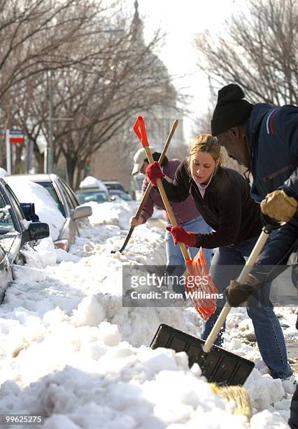 Capitol Hill resident Ashley Cohen, center, and her roommate Rebecca Benn, shovel Cohen's car out of the snow, Tuesday, at 4th and East Capitol....
