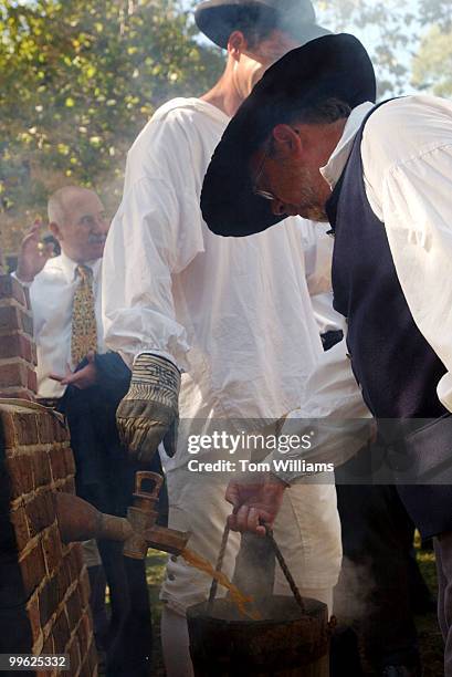 Gerald Webb, Master Blender at Diageo, pours spent mash out of a reproduction still, after a ceremony to lay a cornerstone at the site of the...