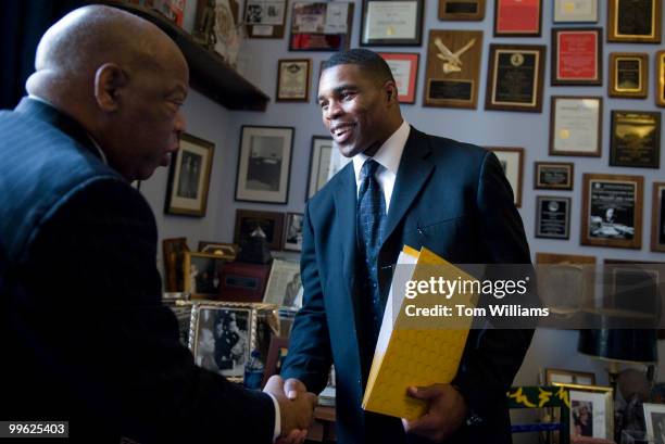 Herschel Walker, Heisman Trophy winner, greets Rep. John Lewis, D-Ga., before a meeting to talk about the importance of physical fitness and...