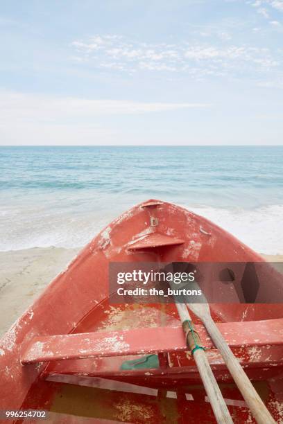 red rowing boat at the beach by sea - burgau portugal stock pictures, royalty-free photos & images
