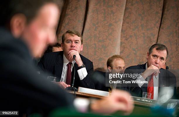 Sens. Michael Bennet, D-Colo., left, and Jeff Merkley, D-Ore., listen to testimony from Treasury Secretary Tim Geithner at a Senate Banking Committee...