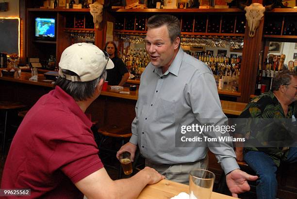 Senate candidate Jon Tester talks with Dennis Alexander at a fundraiser at the Mint Bar and Cafe in Belgrade, Montana.