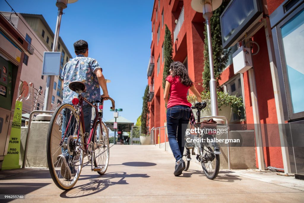 Los Angeles Couple Pushing Bicycles Onto Light Rail Platform