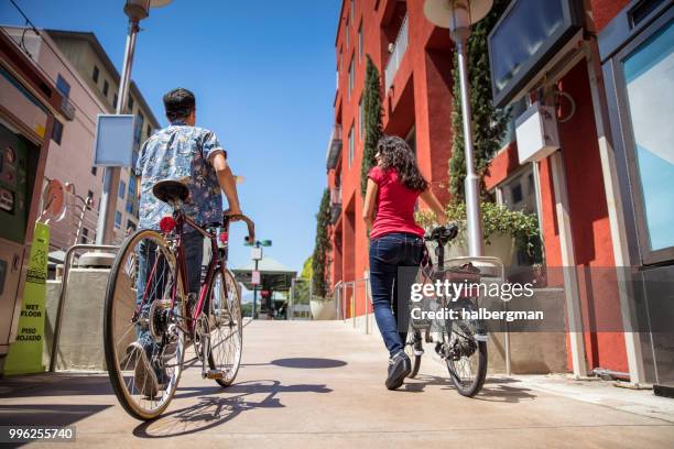 los angeles couple pushing bicycles onto light rail platform - pasadena califórnia imagens e fotografias de stock