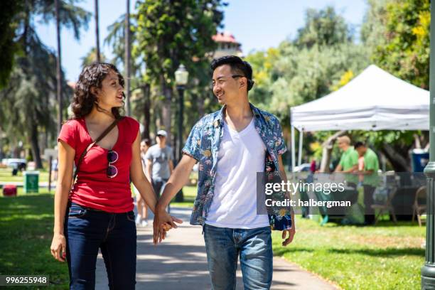 los angeles couple walking through park during farmer's market - pasadena califórnia imagens e fotografias de stock