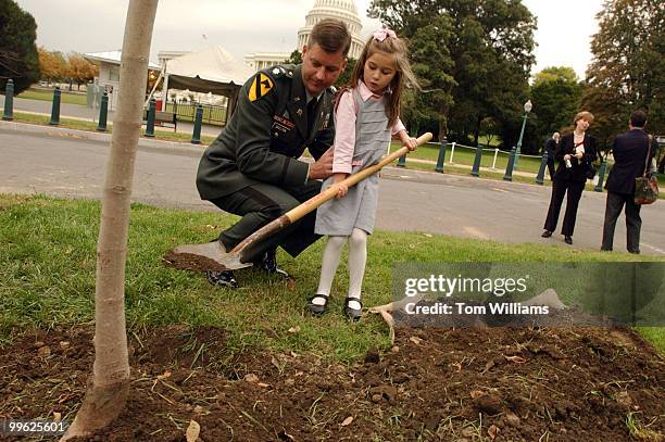 Lt. Col. Jim Skelton and his daughter Sarah put dirt on a Norway Maple tree that was planted in memory of Skelton's mother, Susie Skelton, wife of...