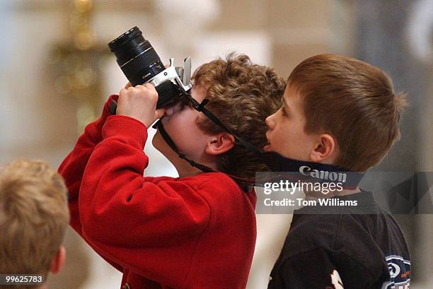 At left, Alec Barnett of New York City, and Ryan Brandt of Conn., take pictures in Statuary Hall during a Capitol tour.