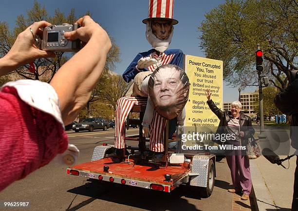 Mary Kay Peterson of Michigan, poses with a 12 foot statue of Uncle Sam reprimanding House Majority Leader Tom Delay, R-Texas, for Delay's ethics...