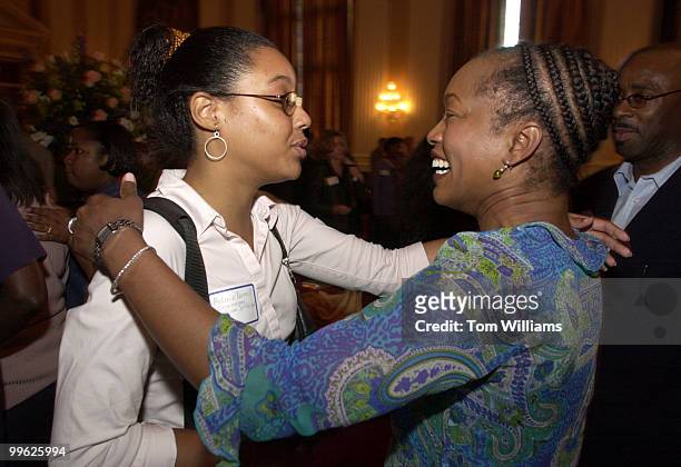 At left, Melanie Roussell, intern for Rep. William Jefferson, D-LA, gives a hug to actress Angela Bassett at a reception in the Cannon Caucus Room in...