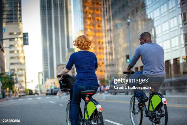 aantrekkelijke la paar rijden aandeel fietsen - bicycle rental stockfoto's en -beelden