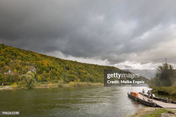 thunderclouds over the ferry landing at the danube near matting, bavaria, germany - engels stock pictures, royalty-free photos & images