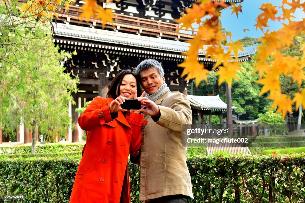Japanese Couple in their 40's Taking Selfie at Tofuku-ji Temple, Kyoto
