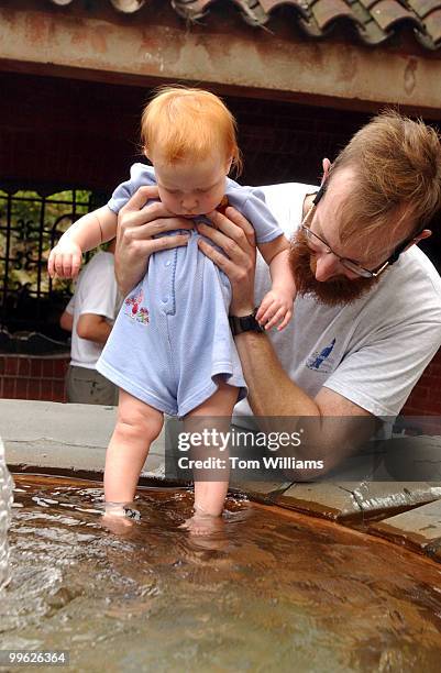 Mack Muir of Reston, cools his niece Bethany of Texas, in the grotto, on the West Front of the Capitol. The temperature reached into the 90's on...