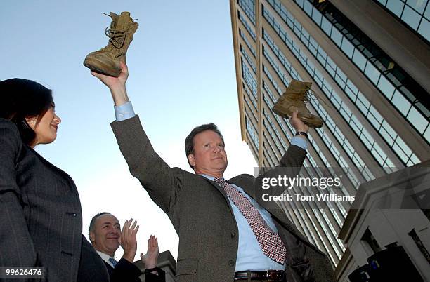 Senator-elect Jim Webb, D-Va., holds his son's combat boots that he campaigned in, at a rally at Courthouse Plaza in Arlington, in which he announced...