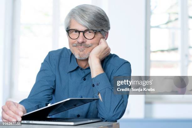 man with laptop leaning on a desk - krebs stock pictures, royalty-free photos & images