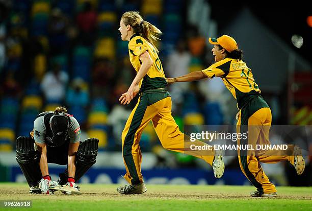 Australian players Ellyse Perry and Lisa Sthalekar celebrate as New Zealand player Elizabeth Perry kneels at the end of the Women's ICC World...