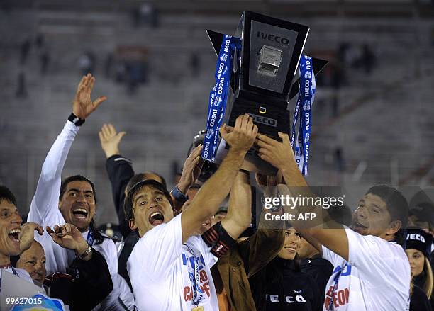 Argentinos Juniors' footballers Matias Caruzzo and Nestor Ortigoza hold up the trophy after their Argentina first division football match against...