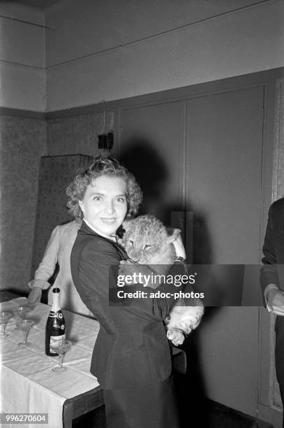 Line Renaud , French actress and singer born in Pont-de-Nieppe holding a lion cub, 1950.