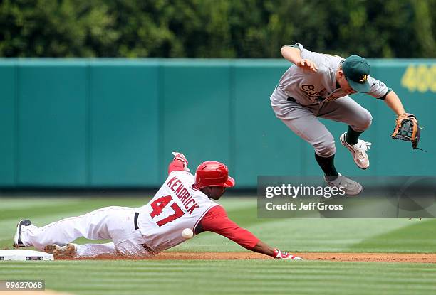 Howie Kendrick the Los Angeles Angels of Anaheim slides into shortstop Cliff Pennington of the Oakland Athletics and breaks up a double play in the...