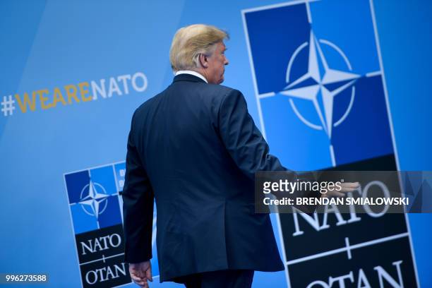 President Donald Trump waves after being welcomed by the NATO Secretary General for the NATO summit at the NATO headquarters in Brussels on July 11,...