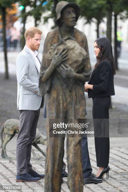 Prince Harry, Duke of Sussex and Meghan, Duchess of Sussex view the Famine Memorial on the bank of the River Liffey during their visit to Ireland on...